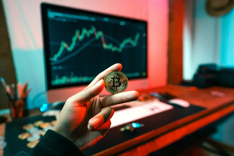 Bitcoin figurát tart egy kéz