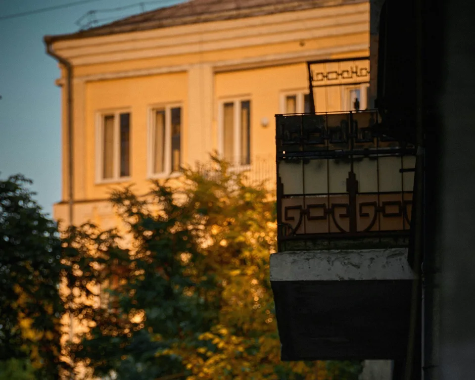 európai belvárosi épület naplementében, előtérben erkély